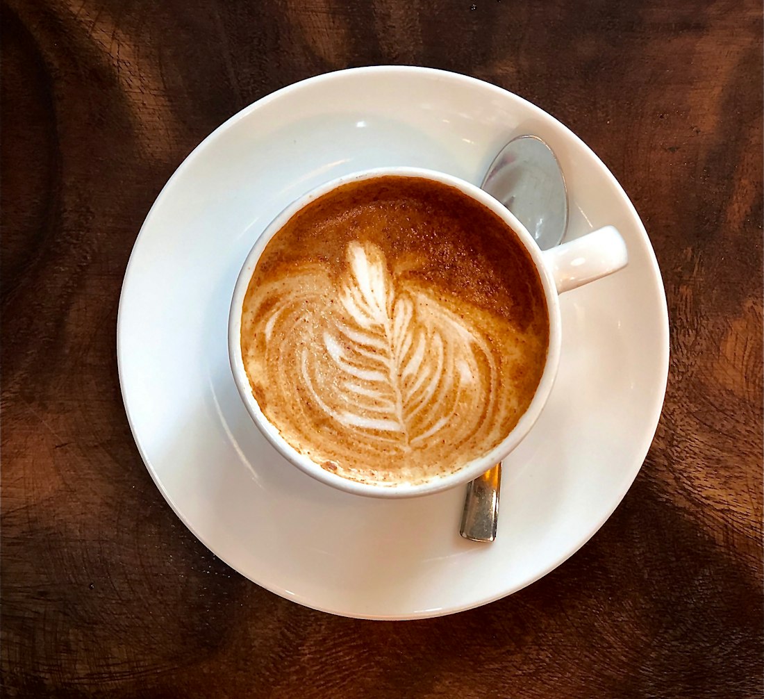 Flat white with latte art on a saucer