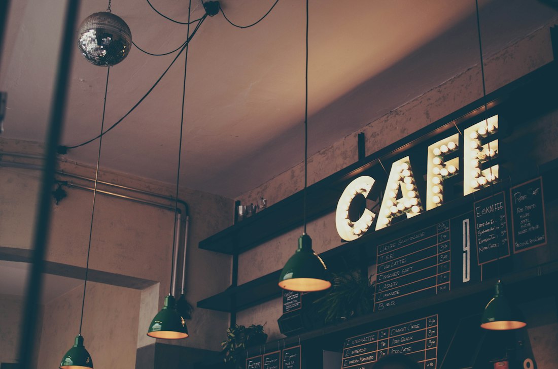 Moody café interior with a glowing café sign