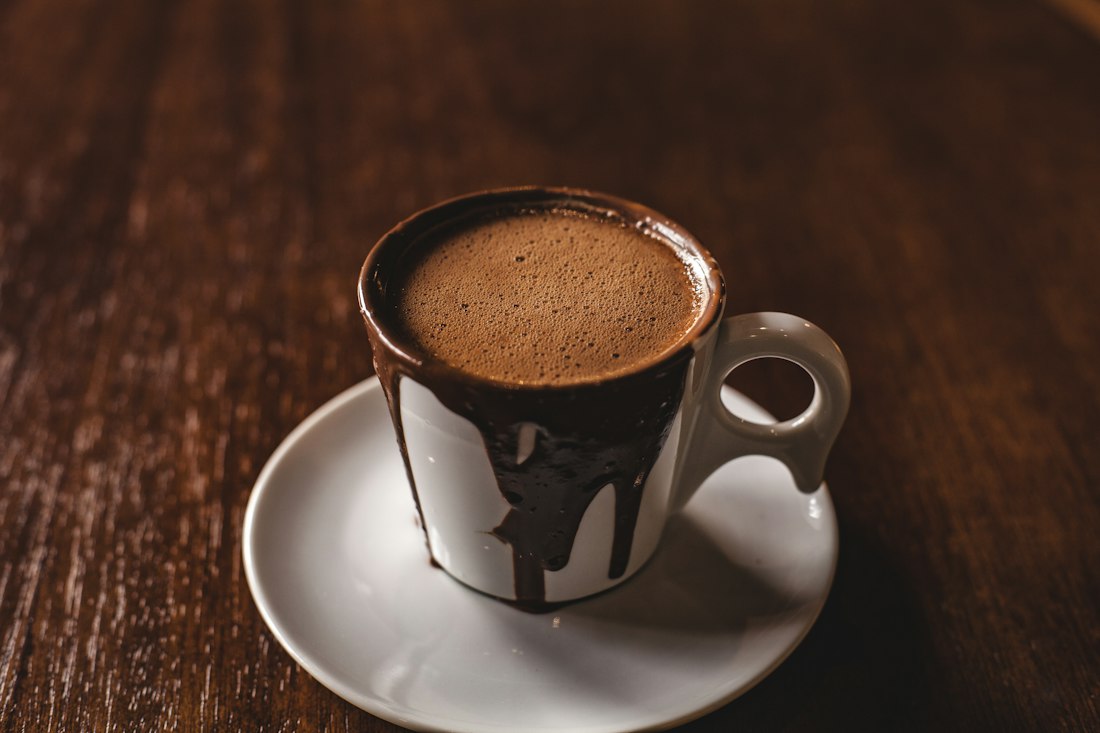 Rich hot chocolate in a cup on a dark wooden table
